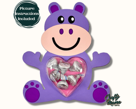 a purple hippo holding a heart filled with candy