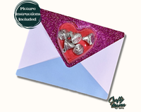 an envelope with a heart shaped candy in it