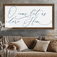 O come let us adore Him sign in a living room with a couch and a christmas tree