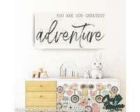 a white dresser with a sign above it that says you are our greatest adventure