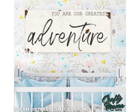 a baby crib with a sign that says you are our greatest adventure