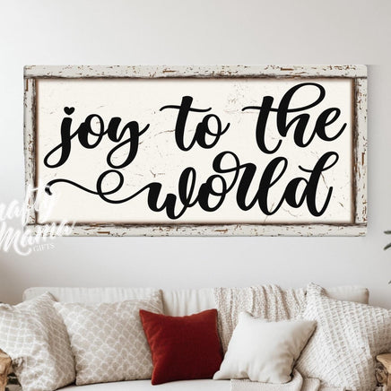 Joy to the world sign in a living room with a couch and a christmas tree