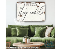 a green couch sitting in a living room under a wooden sign