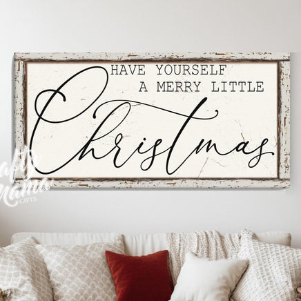 Have yourself a merry little Christmas sign in a room with a white couch next to a christmas tree