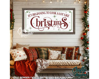 a christmas sign hanging on a wall next to a couch
