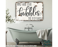 a bathroom with a tub and a sign that says you are the bubbles to my