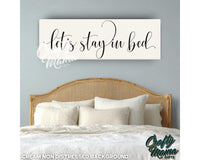 a bedroom with a bed and a sign that says let&#39;s stay in bed