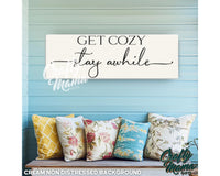 a sign that says get cozy stay awhile