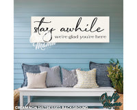 a bench with pillows and a sign that says stay awhile we&#39;re glad you