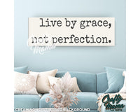 a living room with a blue couch and a white sign that says live by grace