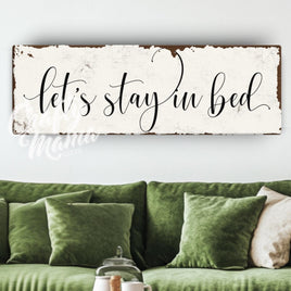 a living room with a green couch and a sign that says let&#39;s stay