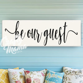 a wooden sign that says be our guest