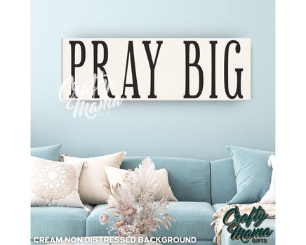 a living room with a blue couch and a sign that says pray big