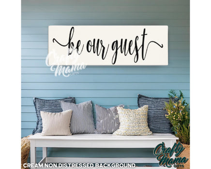 a bench with pillows and a sign that says be our guest