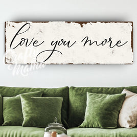 a living room with a green couch and a sign that says love you more