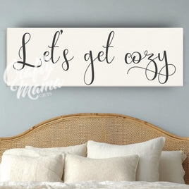 a bedroom with a bed and a sign that says let&#39;s get cozy