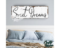 a bed with a wooden sign above it that says sweet dreams