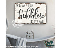 a bathroom with a tub and a sign that says you are the bubbles to my