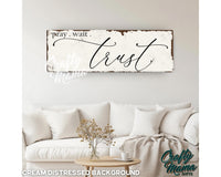 a wooden sign that says pray wait and trust