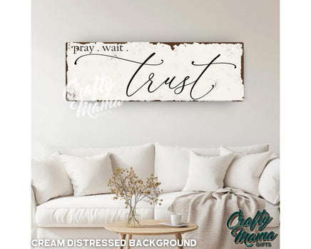 a wooden sign that says pray wait and trust